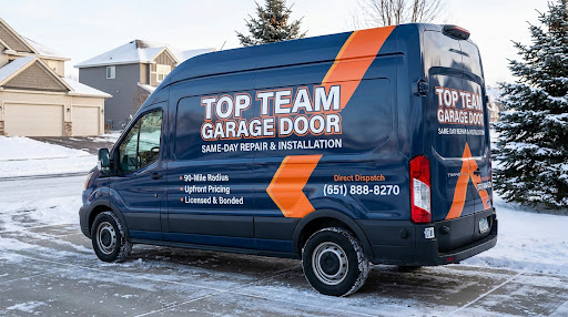 Top Team Garage Door service van parked on a snowy suburban Twin Cities street with two-car attached garages behind it